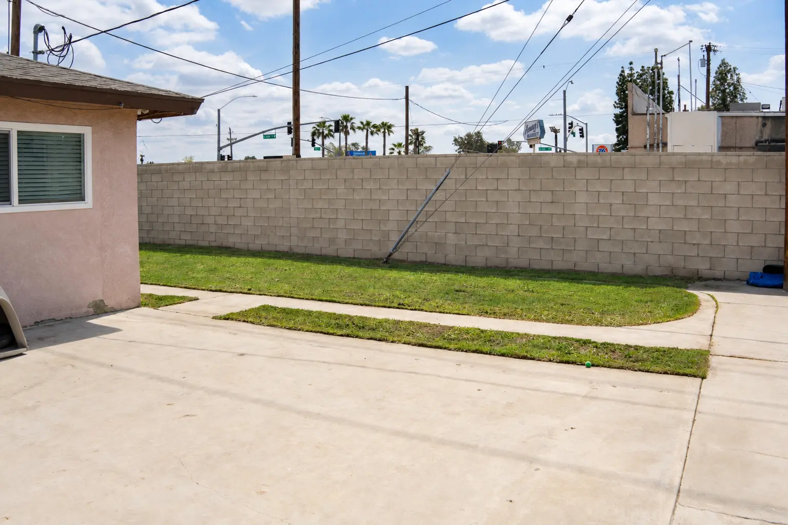 Backyard lawn and patio with block wall