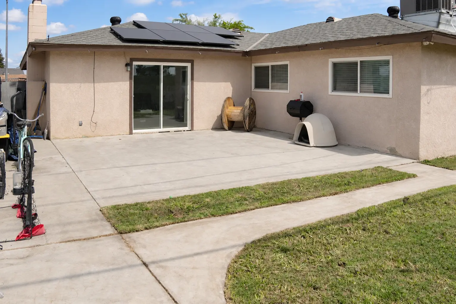 Rear patio and yard with solar-equipped roofline